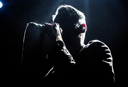 silhouette of man singing on stage